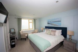 Schlafzimmer mit einem Bett, einem Schreibtisch und einem TV in der Unterkunft Seaclusion Luxury Guest Accommodation in Waterville