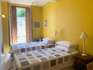 MagalasにあるGite 1の黄色い部屋 ベッド2台 窓付