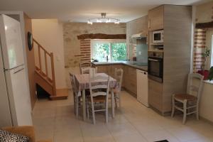 a kitchen with a table and chairs and a refrigerator at GITES CLODEGUY No 2 in Saint-Sylvestre-sur-Lot