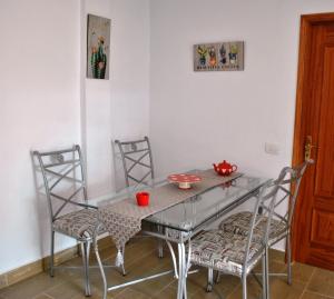 comedor con mesa de cristal y sillas en Casa Bermudez, en Breña Alta
