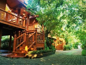 a wooden house with a tree in front of it at Ruen Tai Boutique in Nai Yang Beach