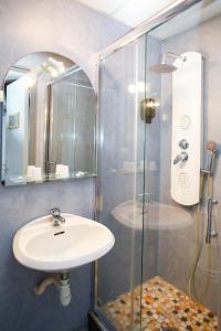 La salle de bains est pourvue d'un lavabo et d'une douche en verre. dans l'établissement Entre Mer et Montagne, à Digoin