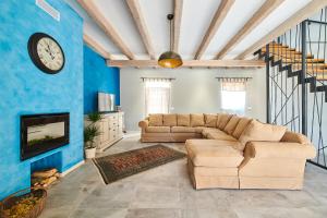 uma sala de estar com um sofá e um relógio na parede em Villa Celeste em Umag