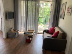 a living room with a couch and a large window at REZYDENCJA ZEFIR AUGUSTOW (Podlasie) in Augustów