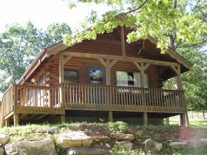a log cabin with a large porch and windows at Mill Creek Resort on Table Rock Lake in Lampe