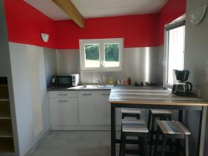 a kitchen with red walls and a wooden counter top at Le petit pays in Montgivray