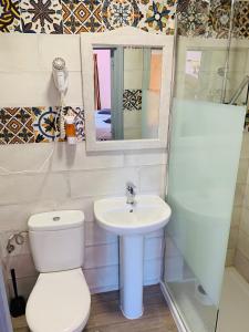 a white toilet sitting next to a sink in a bathroom at Pensión Aduar in Marbella