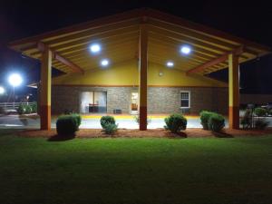 a building with a pavilion at night with lights at Cross Road Motel in Trenton