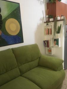 ソルソにあるB&B del Corsoの絵画のあるリビングルームの緑のソファ