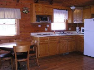 a kitchen with a table and a white refrigerator at Mill Creek Resort on Table Rock Lake in Lampe