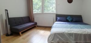 a bedroom with a bed and a couch at Villa Sunshine in Bagneux