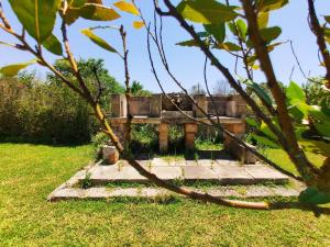 a garden with a bench in the grass at AlliPatuli Apartments in Gallipoli