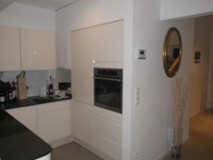 Rading的住宿－Haus Rading，厨房配有白色橱柜和墙上的镜子