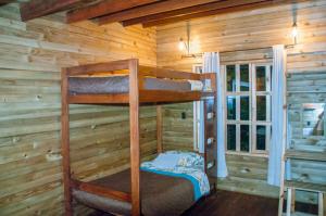 a bedroom with bunk beds in a log cabin at Cabañas ecológicas Xuetama in Villa de Leyva