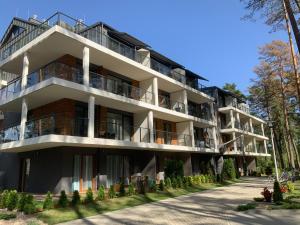 apartamentowiec z balkonami i drzewami w obiekcie REZYDENCJA ZEFIR AUGUSTOW (Podlasie) w mieście Augustów