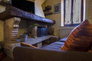 a living room with a fireplace and a couch at Borgo Buio Town House in Montepulciano