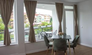 ein Esszimmer mit einem Tisch und einem großen Fenster in der Unterkunft Seasons Hotel in Struga