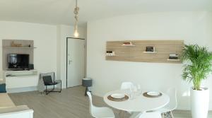ベルガモにあるCasa Sisu - Apartmentの白いダイニングルーム(テーブル、椅子付)