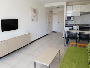 a kitchen with a table, chairs and a refrigerator at Apartamentos Maria Victoria in Benidorm