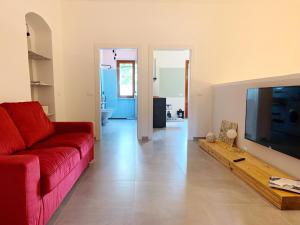 a living room with a red couch and a flat screen tv at House of Arts in Montelupo Fiorentino