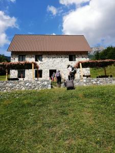 a group of people standing in front of a stone building at Guest house PANORAMA in Theth