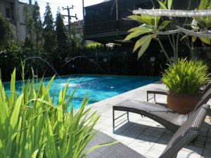 una piscina con un banco y plantas en un patio en Bali World Hotel, en Bandung