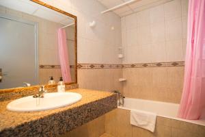 a bathroom with a sink and a tub and a mirror at Hotel Villa Barbara in Can Picafort +40 photos