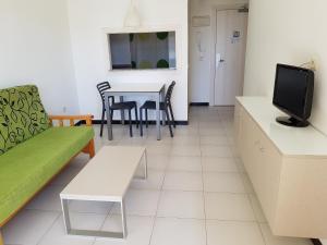 Apartamentos Maria Victoria في بنيدورم: غرفة معيشة مع أريكة وطاولة