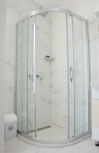 y baño con ducha y mampara de cristal. en Seasons Hotel, en Struga