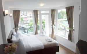 ein Hotelzimmer mit einem Bett und einem großen Fenster in der Unterkunft Seasons Hotel in Struga