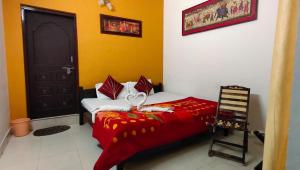 a bedroom with a bed with a red blanket and a black door at Haveli Taragarh Palace in Būndi