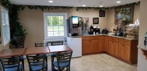 a kitchen with a table and a refrigerator at Scottish Inns Sturbridge in Sturbridge