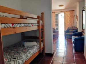 ポルト・サントにあるRefugio das Matasの二段ベッド2台とリビングルームが備わる客室です。