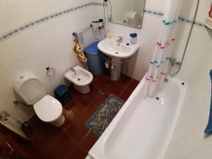 a bathroom with a tub and a toilet and a sink at Refugio das Matas in Porto Santo