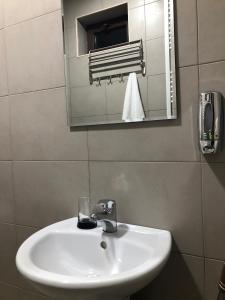 a white sink in a bathroom with a mirror at ELSADA in Stepantsminda