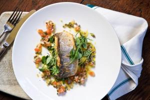 a plate of food with a piece of fish with vegetables at Victoria in Holkham