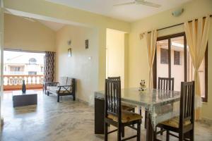 een eetkamer met een tafel en stoelen bij Laxmi's Apartment - Coconut Grove Residence in Orlim