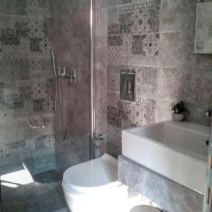 Perseus Studios في سكالا راخونيو: حمام مع دش ومرحاض وحوض استحمام