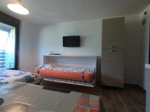 a bedroom with two beds and a tv on the wall at Monolocale Belvedere in Bovec