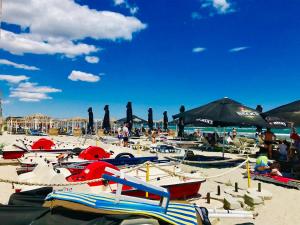 a group of boats on a beach with umbrellas at DarNiDa Luxury Apartment in Mamaia Sat/Năvodari