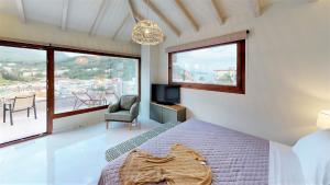 a bedroom with a bed and a tv and a window at Parga Inn Suites in Parga