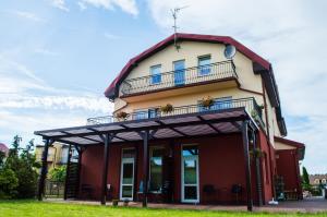 a red and white building with a balcony at ADANIA 1 in Grzybowo