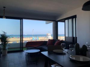 - un salon avec un canapé et une vue sur la plage dans l'établissement Appartement Vue Mer climatisé 2 chambres, à Port-la-Nouvelle