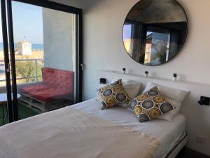 - une chambre avec un lit avec un miroir et un balcon dans l'établissement Appartement Vue Mer climatisé 2 chambres, à Port-la-Nouvelle