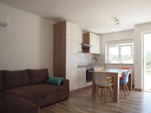 sala de estar con sofá, mesa y cocina en Apartman&Studio S, en Ploče