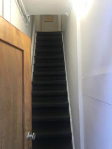 Una escalera con escaleras negras en una habitación con puerta en Olive Bed and Breakfast, en Ámsterdam