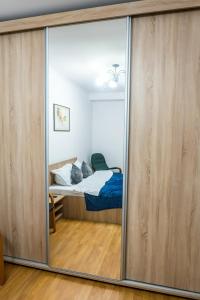 a bedroom with a bed through a sliding glass door at D&O Zola in Timişoara