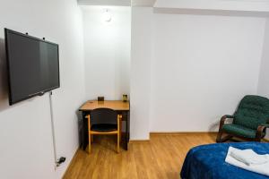 a room with a desk and a tv and a chair at D&O Zola in Timişoara