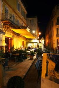 an empty street at night with tables and chairs at Studio climatisé, La Cloison in Arles