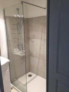 La salle de bains est pourvue d'une douche avec une porte en verre. dans l'établissement Studio climatisé, La Cloison, à Arles